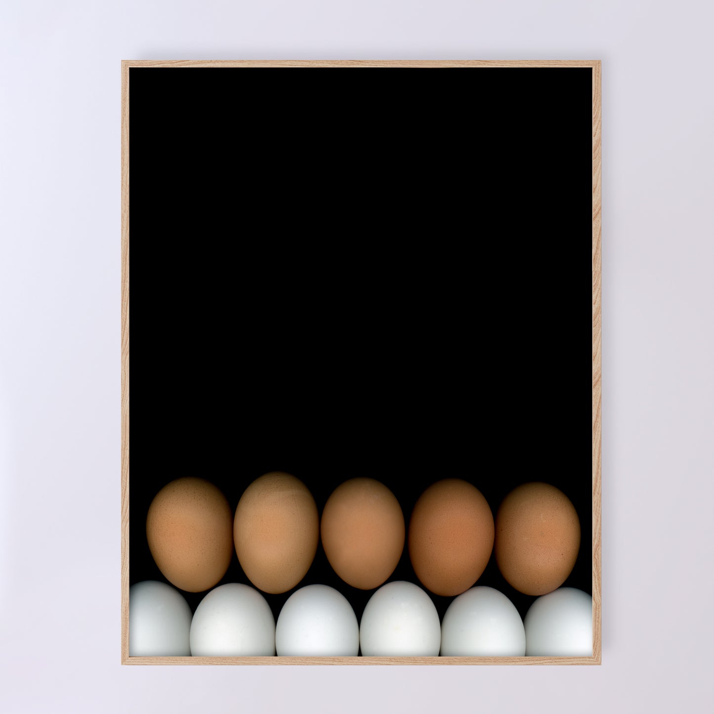 Two rows of chicken eggs one brown row and one white row on a black background in a light beige wood frame. Open edition print by Carmen Grenier. OE-355-2, 11x14 inches.